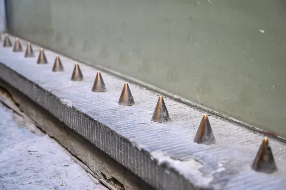 Spikes on building designed to prevent people from sitting.